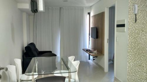 a living room with a glass table and white chairs at Landscape Residence by Escala Imóveis in Fortaleza