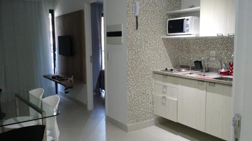 a kitchen with white cabinets and a counter top at Landscape Residence by Escala Imóveis in Fortaleza