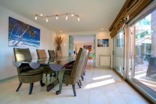 a dining room with a glass table and chairs at Villa Laguna Golf-Frente ao laguna Golf in Vilamoura