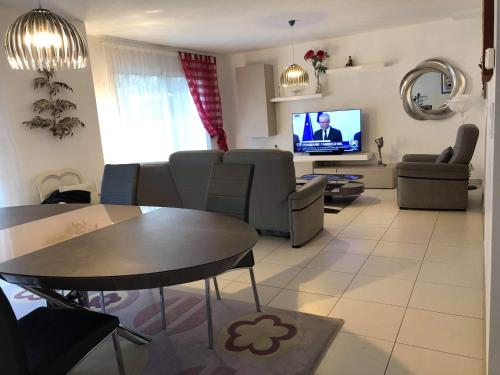 sala de estar con sofá, mesa y TV en Home Auray, en Auray