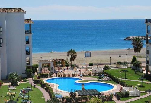Blick auf ein Resort mit Pool und Strand in der Unterkunft Personal y coqueto en primerísima línea de playa, en la Costa del Sol. Puerto De La Duquesa in Castillo de Sabinillas