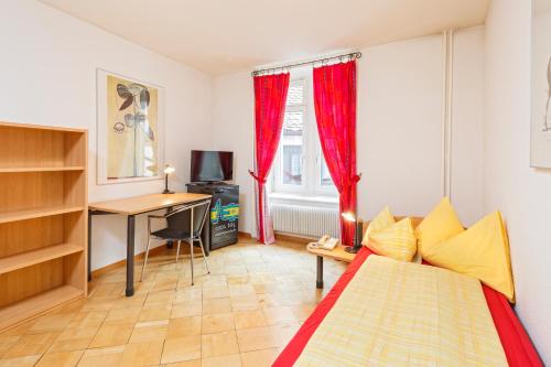 a room with a bed and a desk and a window at Residence zur Musegg in Lucerne