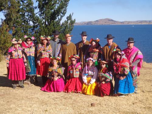 a group of people in traditional costumes posing for a picture at "Casa de Valentin" in Llachon