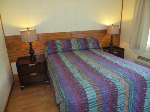 a bedroom with a bed and two night stands with lamps at Cool Springs Inn in Michigan City