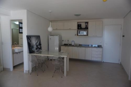 a kitchen with a table and chairs and a refrigerator at Landscape Residence by Escala Imóveis in Fortaleza