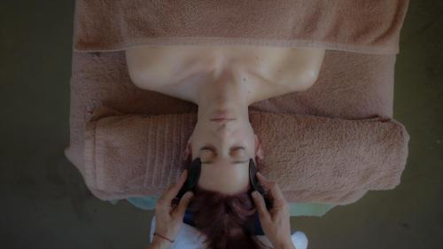a woman holding two cell phones to her face at Enagron Ecotourism Village in Axós