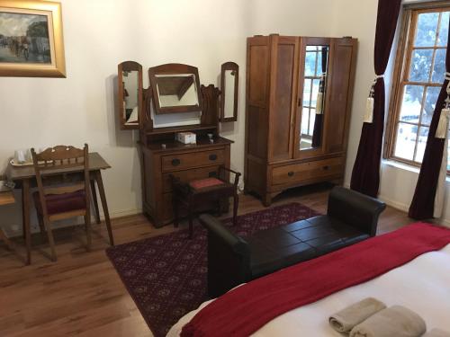 a bedroom with a bed and a dresser and a mirror at Towerzicht Guest House in Ladismith