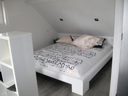 un piccolo letto bianco in una camera bianca di yinloft a Sainte-Gemme-Moronval