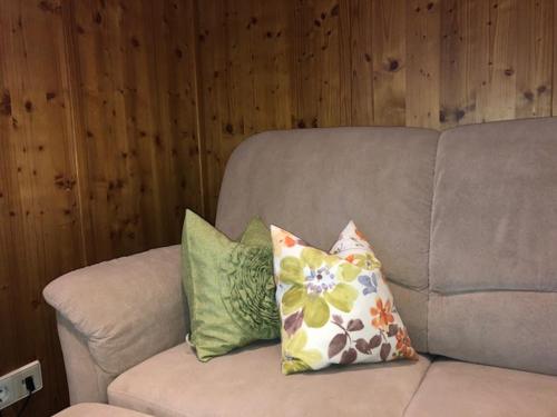 a couch with three pillows on top of it at Ferienwohnung HOF in Mühlenbach