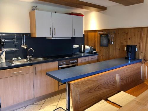 a kitchen with wooden cabinets and a blue counter top at Ferienwohnung HOF in Mühlenbach