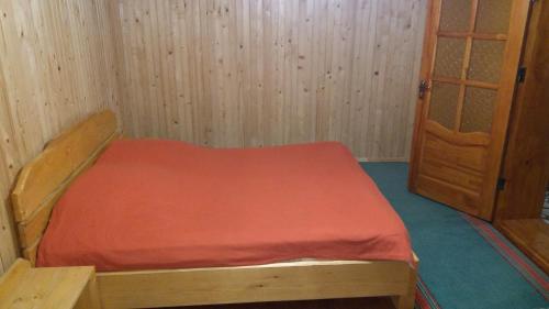 Cette petite chambre comprend un lit et une porte. dans l'établissement Базилік Люкс, à Yaremtche