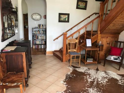 a living room with a staircase and a table and chairs at Towerzicht Guest House in Ladismith
