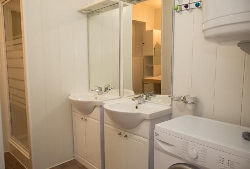 Baño blanco con 2 lavabos y espejo en Gites L'épilobe, en Saint-Léger-les-Mélèzes