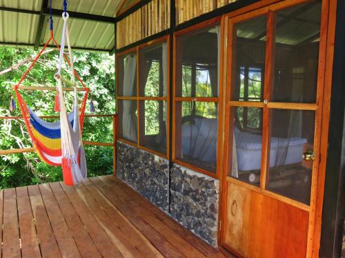 a porch of a house with a hammock on it at La Bambouseraie in Balgue