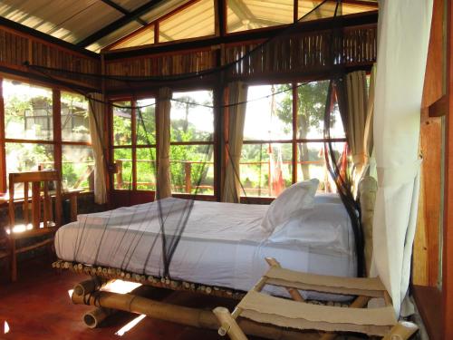 a bedroom with a bed in a room with windows at La Bambouseraie in Balgue