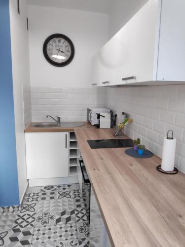 une cuisine avec un comptoir et une horloge au mur dans l'établissement Best Apart - Nice Port - Balcony, à Nice