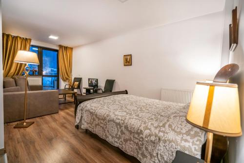Habitación de hotel con cama y sofá en Ripsime Colina Marei, en Sinaia