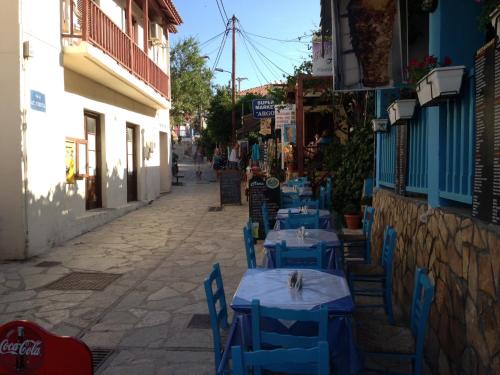 a row of blue tables and chairs on a street at Konstantina Studios in Agios Nikitas