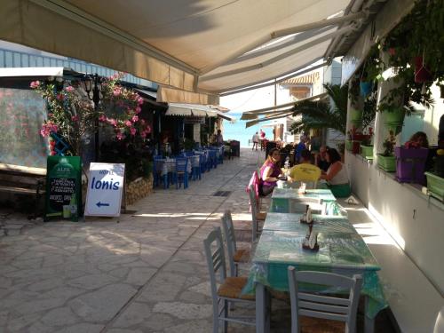 Eine Frau steht neben einem Tisch in einem Restaurant. in der Unterkunft Konstantina Studios in Agios Nikitas