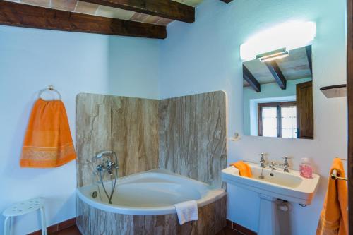a bathroom with a tub and a sink at Villa El Olivo in Pollença