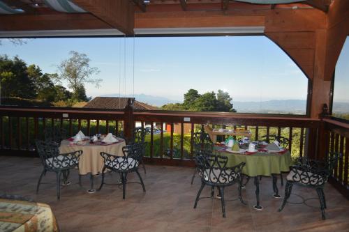 a patio with tables and chairs on a deck at Finca Paraiso Mountain Retreat near San Jose Airport in Birrí