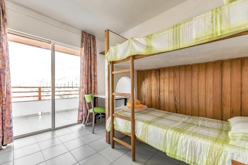 1 dormitorio con 2 literas y balcón en Apartamento Palmeras Del Sur, en Adeje