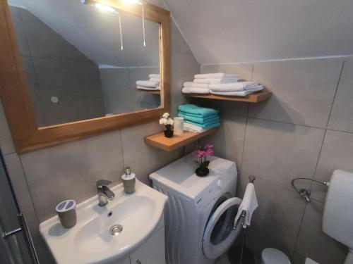 a bathroom with a sink and a toilet and a mirror at Apartment Vesna in Primošten