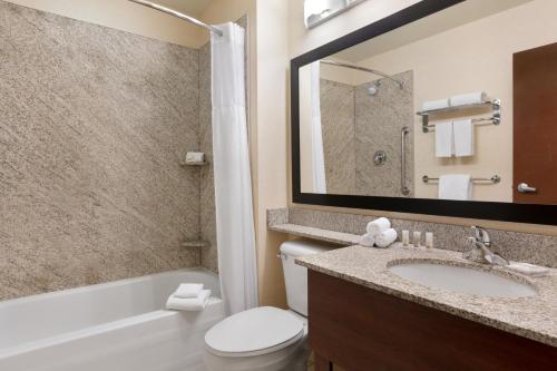 a bathroom with a sink and a toilet and a tub at Days Inn & Suites by Wyndham Sherwood Park Edmonton in Sherwood Park