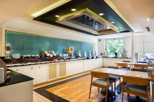 a large kitchen with a table and chairs at Artur Hotel in Canakkale
