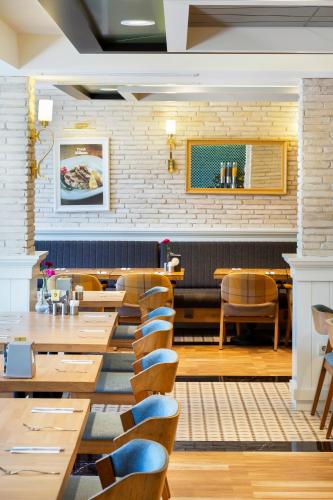 a dining room with wooden tables and chairs at Artur Hotel in Canakkale