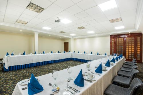 a large room with tables and chairs with blue napkins at Hotel Dann Av. 19 in Bogotá