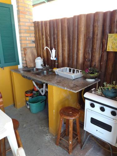 a kitchen with a sink and a stove at Pousada da Tia Lena in Florianópolis