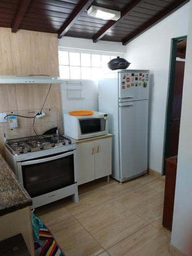 a kitchen with a stove and a refrigerator at Pousada da Tia Lena in Florianópolis