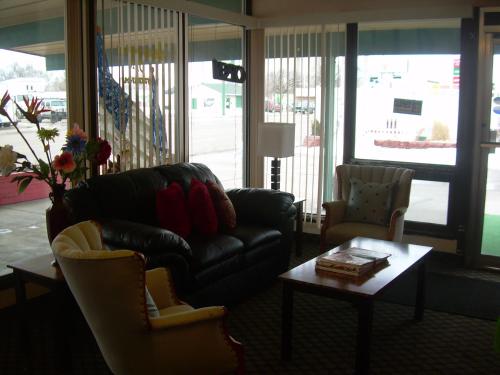 Una sala de estar con un sofá y sillas y una mesa. en 83 motel, en North Platte