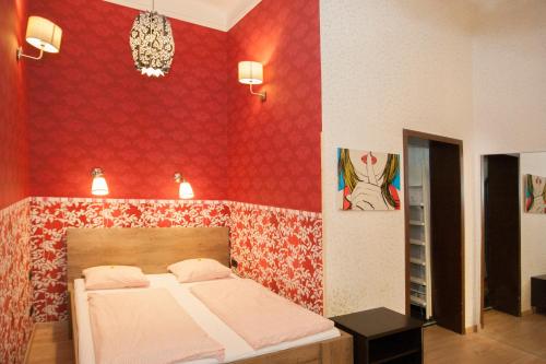 um quarto com uma cama e uma parede vermelha em Inviting flat in the heart of town em Budapeste