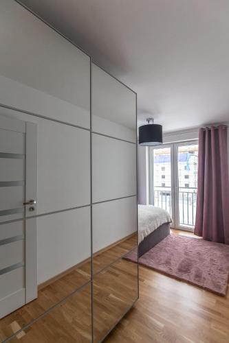 a bedroom with glass walls and a bed and a window at Apartament Soft 14 in Biała Podlaska