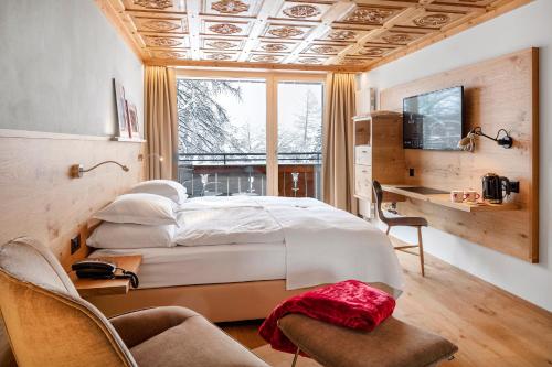 Postel nebo postele na pokoji v ubytování Swiss Alpine Hotel Allalin