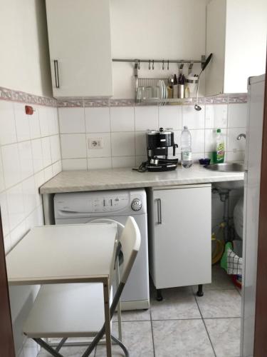 a small kitchen with white appliances and a chair at Sofia Holiday Home in Rome
