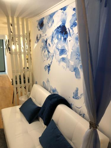 リスボンにあるBlue Urban Alfamaの青い絵画が飾られた部屋の白いソファ