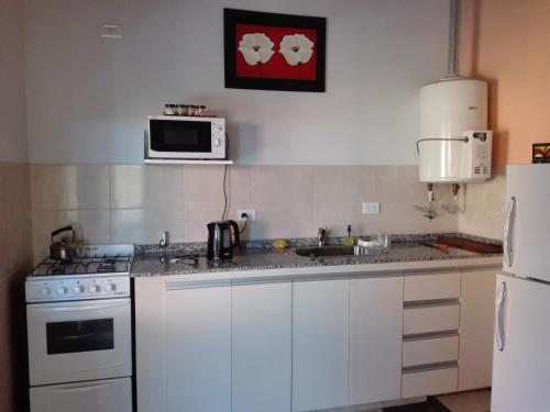 cocina con electrodomésticos blancos y microondas en Casas de Sierras Da Car en Santa Rosa de Calamuchita