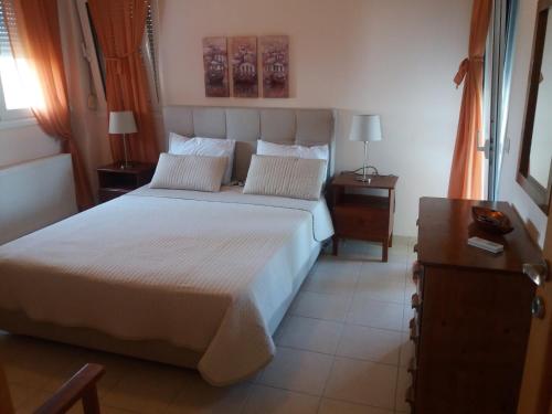 a bedroom with a large white bed with two night stands at Villa Achilleos in Possidi