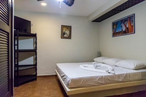 a bedroom with a bed with white sheets at Moonshine Hotel in Playa del Carmen