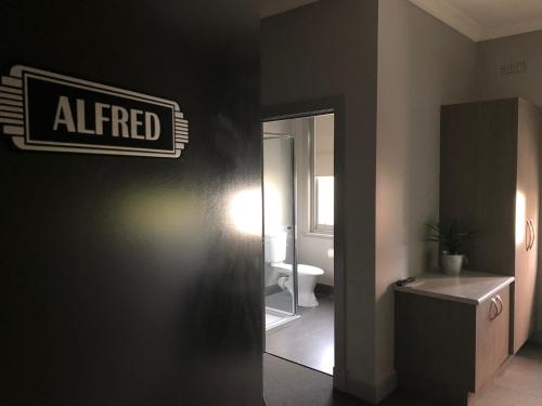 a bathroom with a sign that reads altered on the wall at The Royal Hotel, Drouin in Drouin