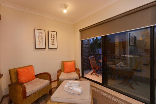a room with two chairs and a table and a window at Seascape Holidays - Hibiscus in Port Douglas