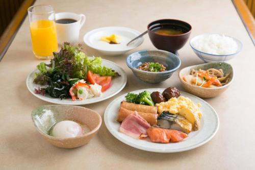 a table with plates of food and bowls of food at Gifu Washington Hotel Plaza in Gifu