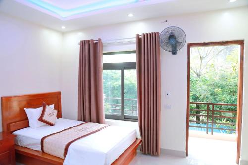 a bedroom with a bed and a large window at Tam Coc Legend Hotel in Ninh Binh