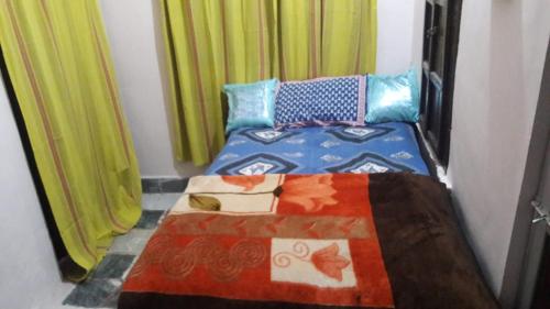 um quarto com uma cama com um edredão colorido em Bhavyam HomeStay &Cafe BackPackers ko em Bundi
