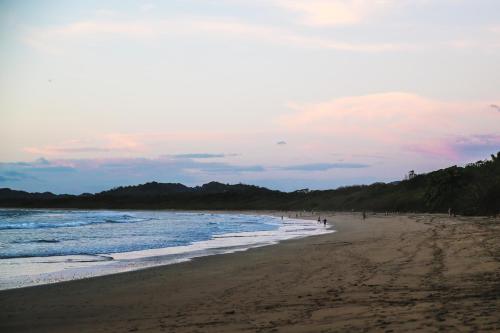a group of people walking on the beach at Pipe House Playa Grande in Playa Grande