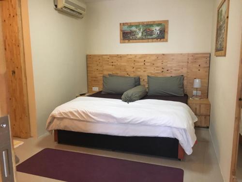 Schlafzimmer mit einem großen Bett mit einem Kopfteil aus Holz in der Unterkunft YNT 2 Bedroom Apartment with city View in Nagoya