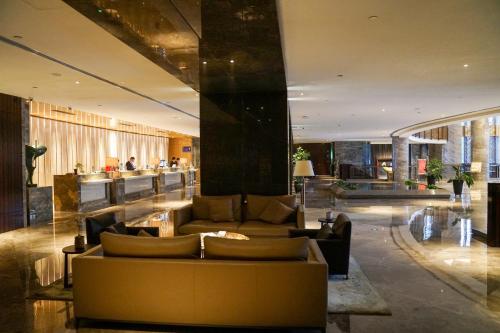 a lobby with couches and a bar in a building at Fulitai International Hotel in Yantai